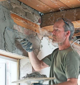 Ny gipsloft med synlige bjælker: Træk pudsemørtlen på væggen Ny gipsloft med synlige bjælker: Træk pudsemørtlen på væggen